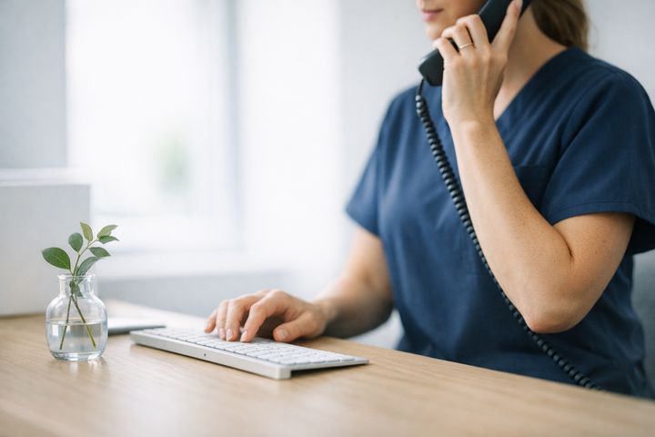 Axis Pain Group patient coordinator answering a call at the front desk